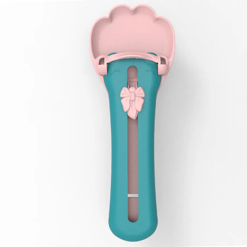Green and pink pet feed spoon with silicone barrel for squeezing out sticky dog or cat food.