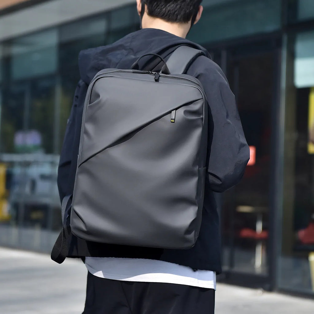 Waterproof laptop backpack in black showing large main compartment and simple design with sewing thread detailing