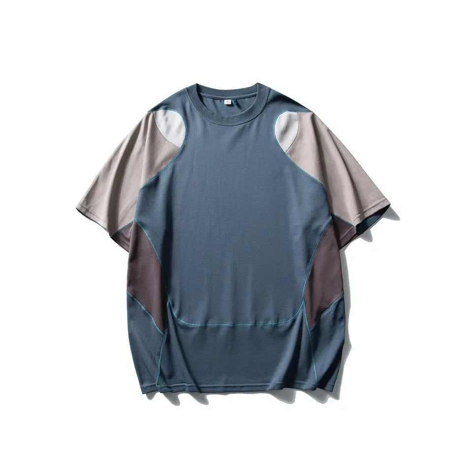 Man wearing a loose fit patchwork t-shirt in a solid colour with short raglan sleeves.