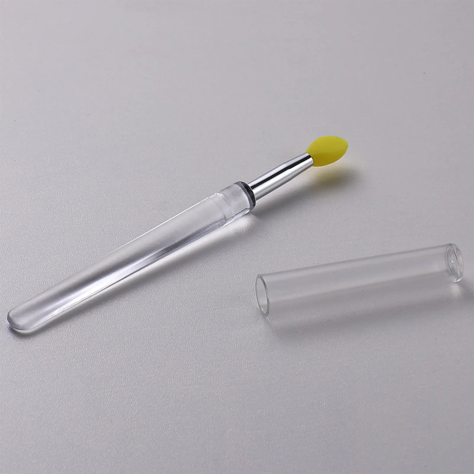 Set of coloured silicone lip brushes with protective caps for applying lipstick and lip gloss.