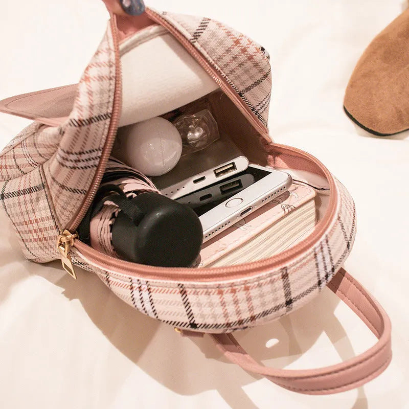 A black one shoulder diagonal phone bag made from PU fabric, shown being worn.