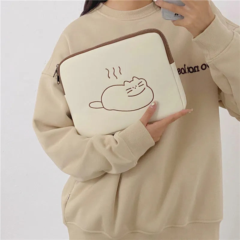 Embroidered fat cat design on a navy blue nylon tablet protective sleeve with a black zip.