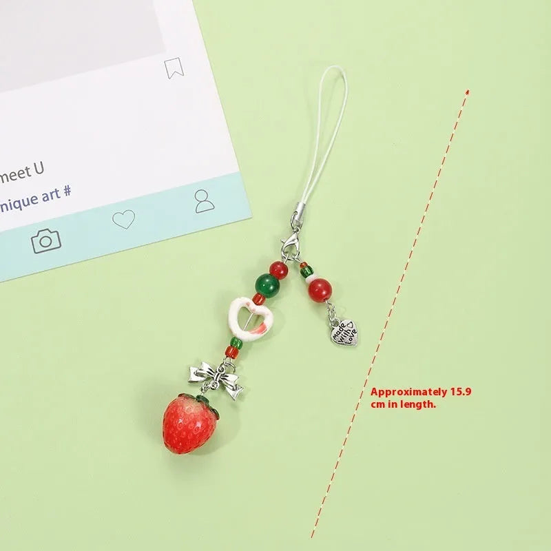 Plastic resin fruit pattern phone charm keychain pendant with apple and strawberry designs on a white rope.