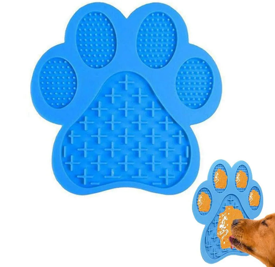 Blue silicone dog licking mat with bone texture and suction cups on a white bathroom tile.