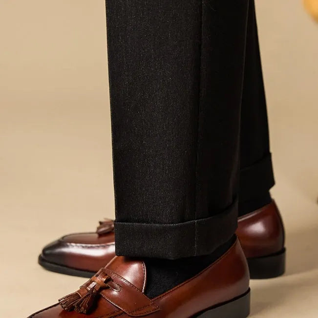 Men's black and brown tassel loafers with polished leather uppers and rubber soles