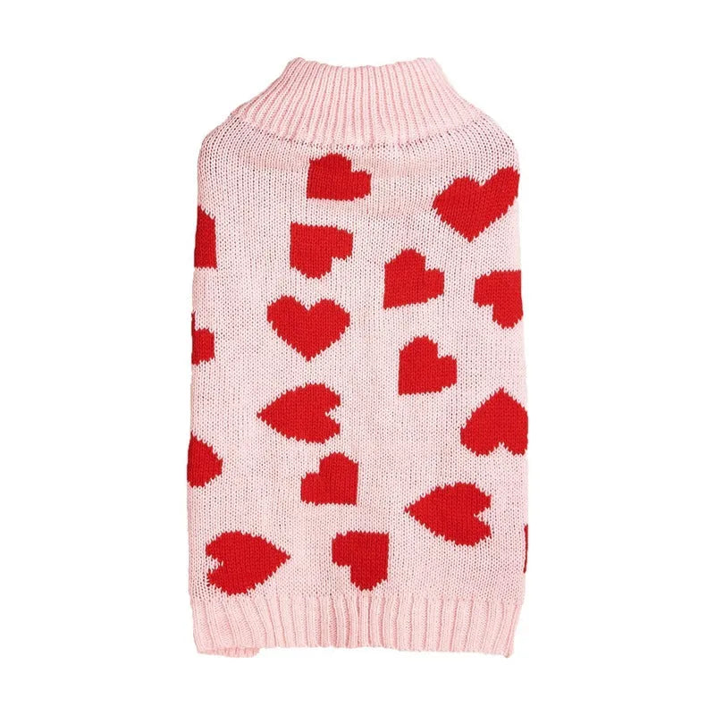Dog wearing acrylic jumper with love heart and bow designs in red and pink colour patterns
