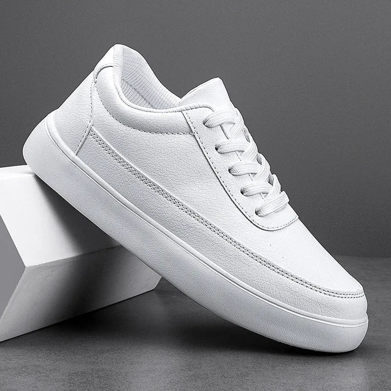 Women's white leather lace-up casual flat trainers on a plain background.