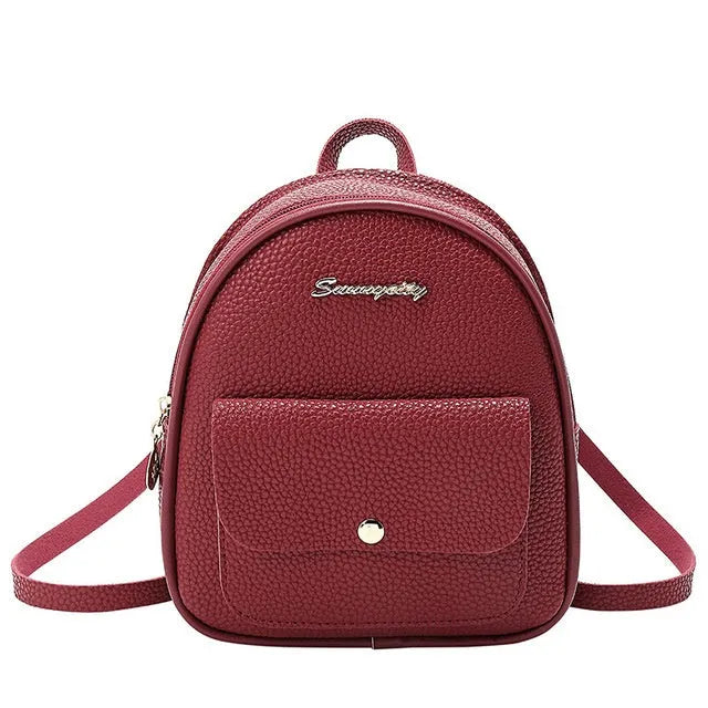 Small black PU shoulder backpack for women with zipper, shown next to a mobile phone for scale.