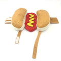 A small dog wearing a stuffed hot dog costume with a padded sausage midsection.