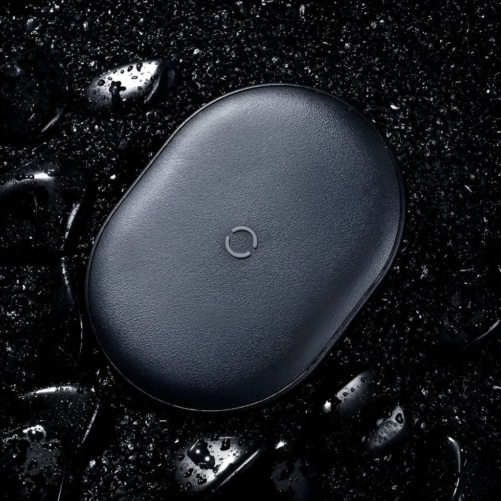 Baseus rough-textured 15W wireless charging pad for mobile phones in black on a desk.