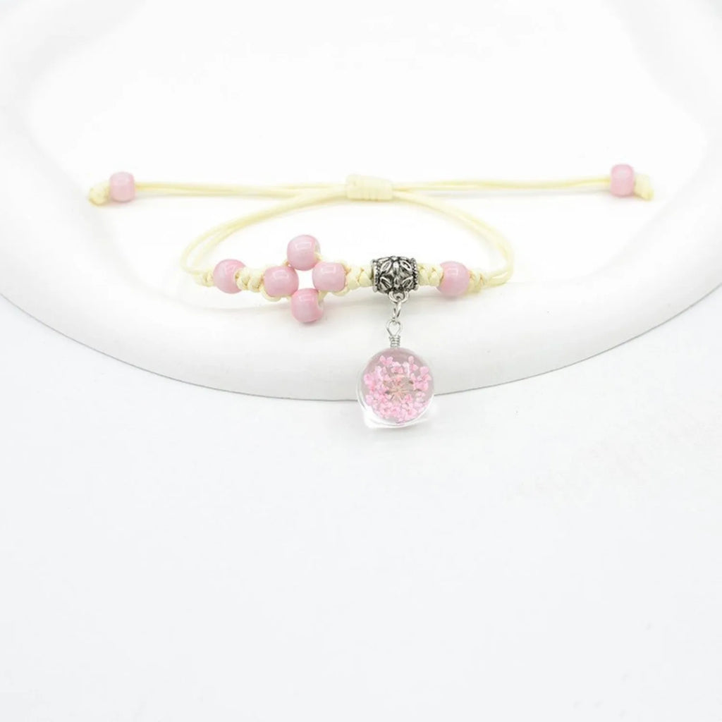 Hand-woven glass bracelet with large 1.4cm beads containing dried real flowers, shown in multiple colour options.