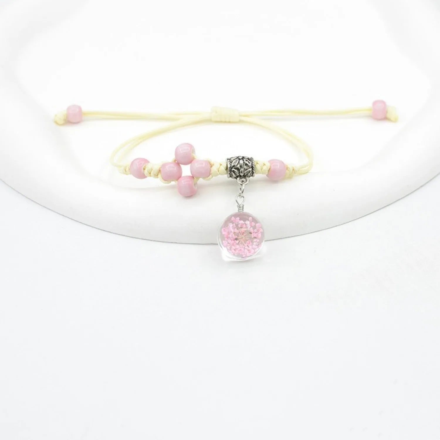 Hand-woven glass bracelet with large 1.4cm beads containing dried real flowers, shown in multiple colour options.