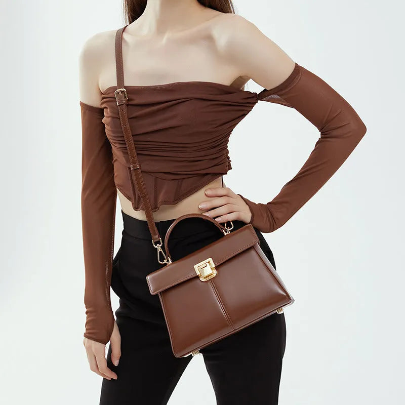Women's black genuine leather shoulder bag with vachette clasp closure showing horizontal square design