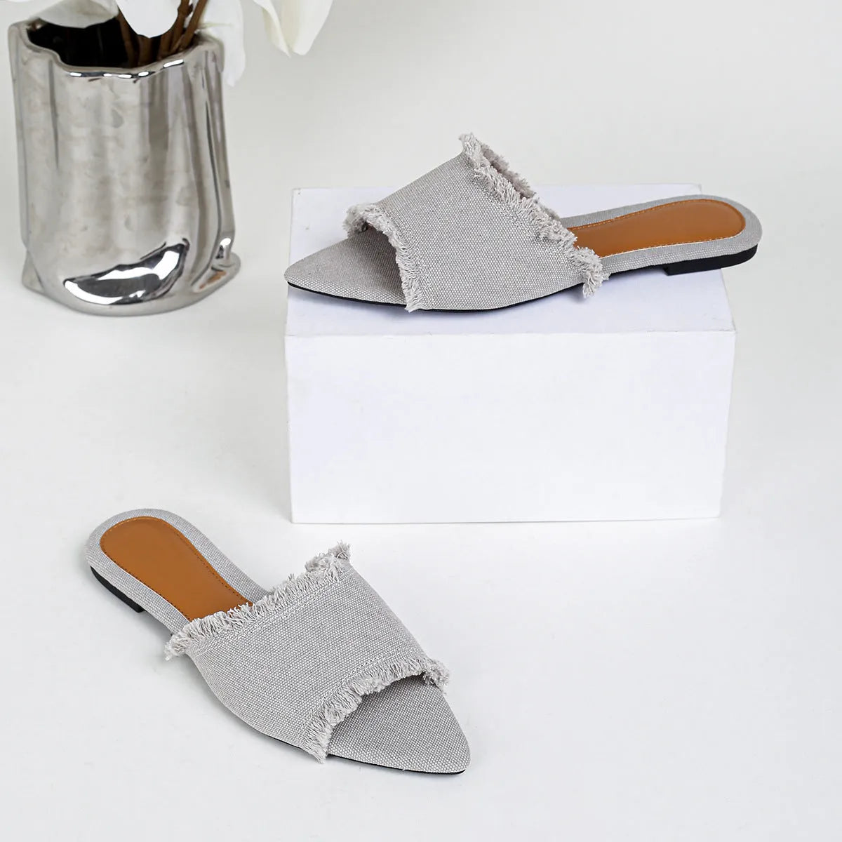 Women's flat denim slippers with tassel detail in apricot colour on a white background