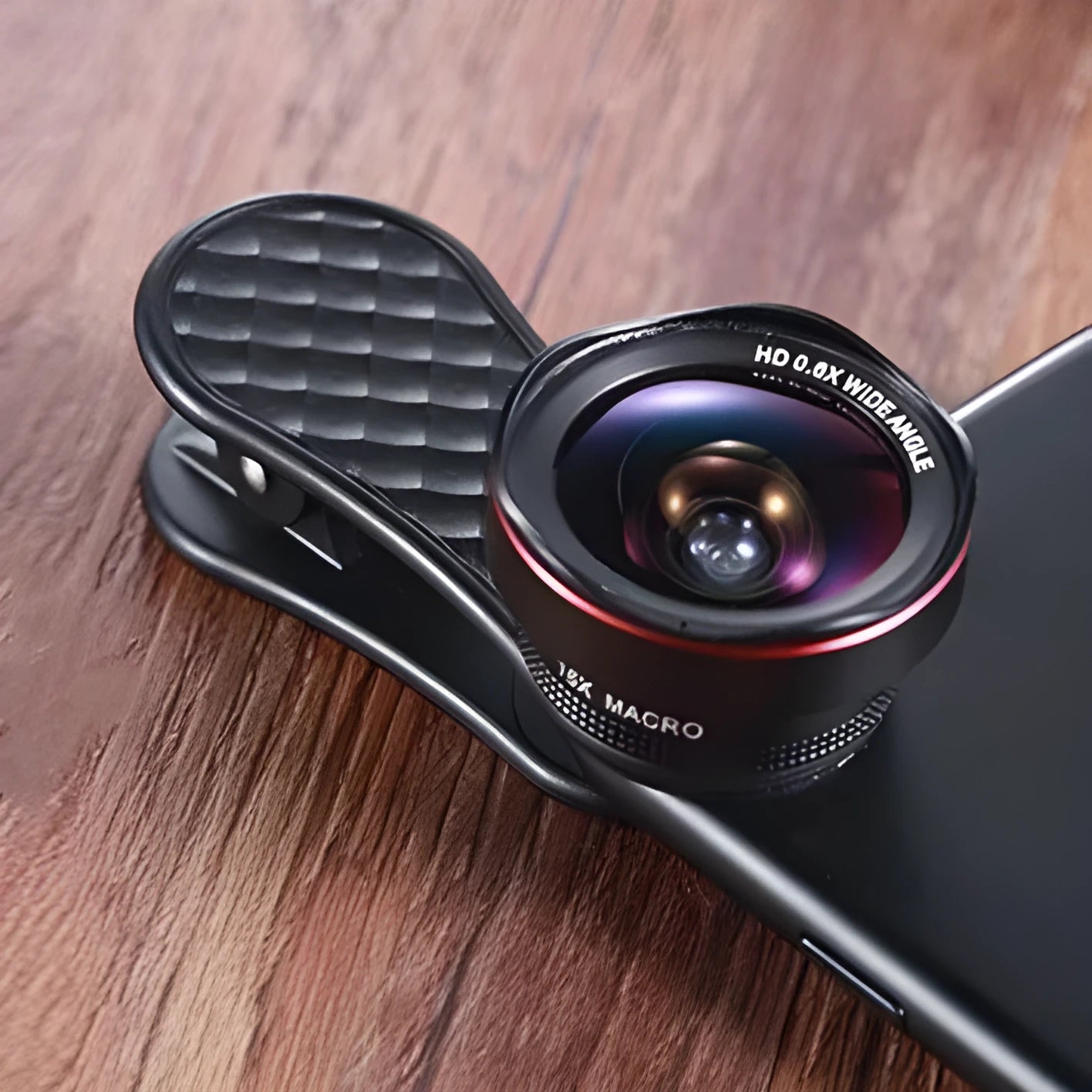 Black mobile phone wide-angle and macro lens kit with clip and storage case on a table.
