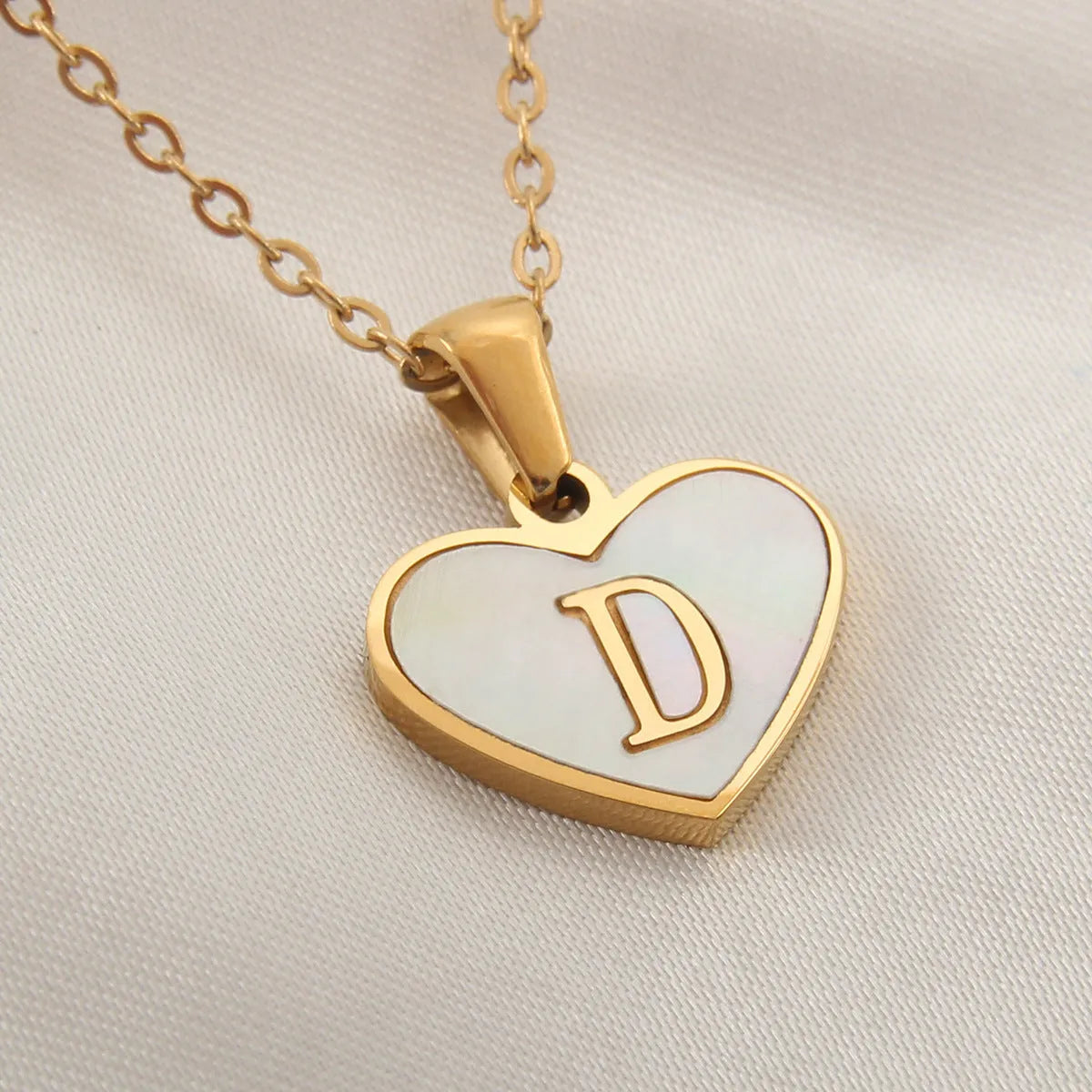 Gold plated heart-shaped personalised necklace with white shell charm on an adjustable chain.