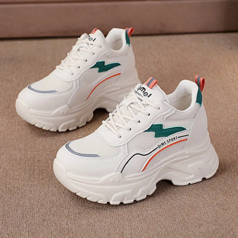 White women's low-top dad shoes with cross straps and lace-up front, showing round toe and rubber sole.