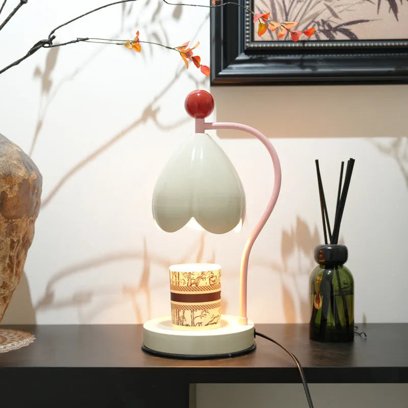 Linglan ancient style melting wax fragrance lamp on a desk, available in cream white or dark green.