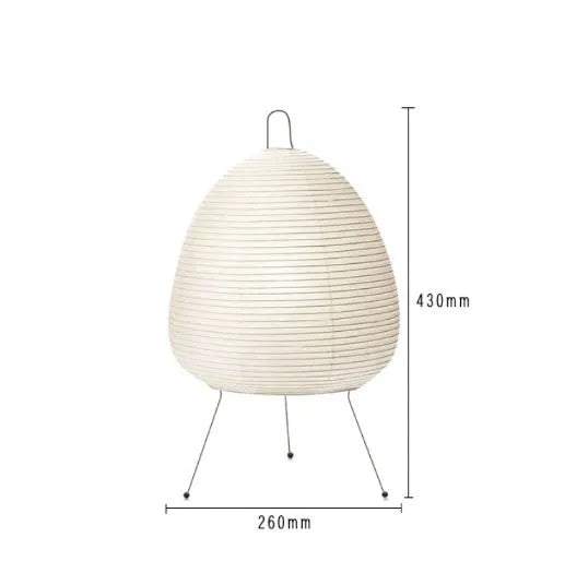 Japanese style handmade rice paper lantern table lamp with aluminium base on a wooden table.