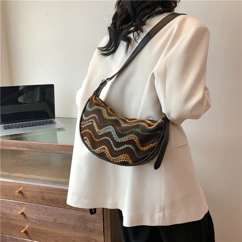Knitted straw woven crossbody bag showing woven texture and internal organisation pockets