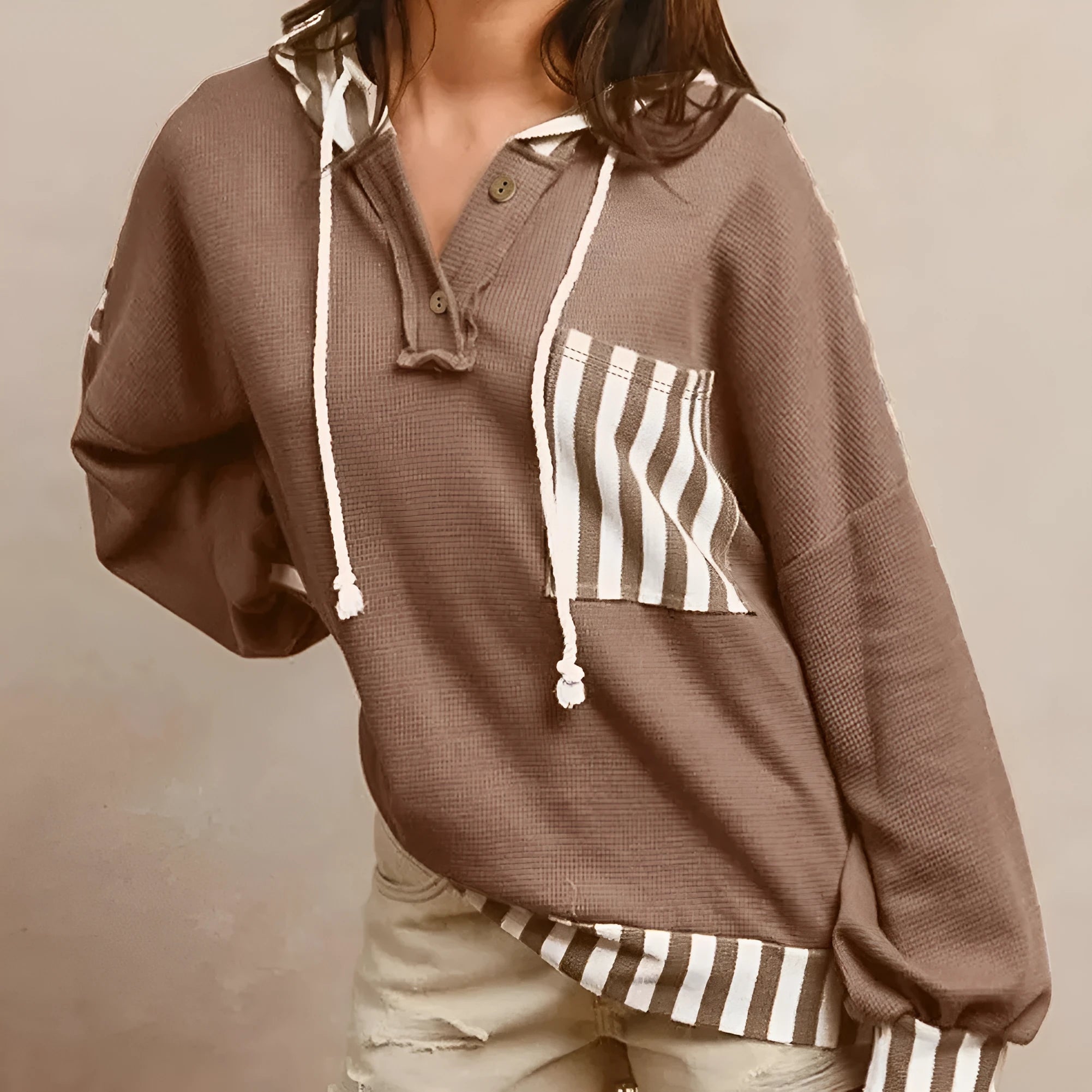 Straw yellow hoodie with waffle texture and striped patchwork design featuring drawstring hood and button neck closure