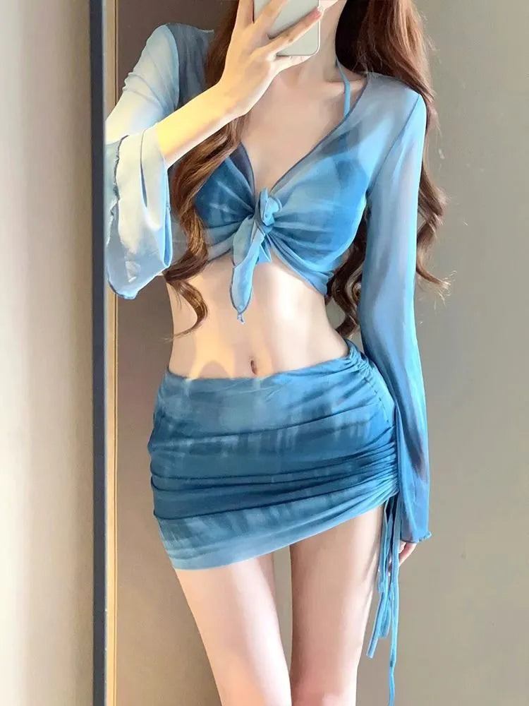 Blue four-piece women's bikini swimsuit set showing shirt, bra, high-waisted briefs, and skirt laid flat.