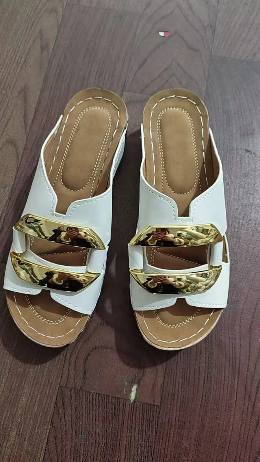 Roman-style platform flip-flops in a solid colour with a metal detail and rubber sole.