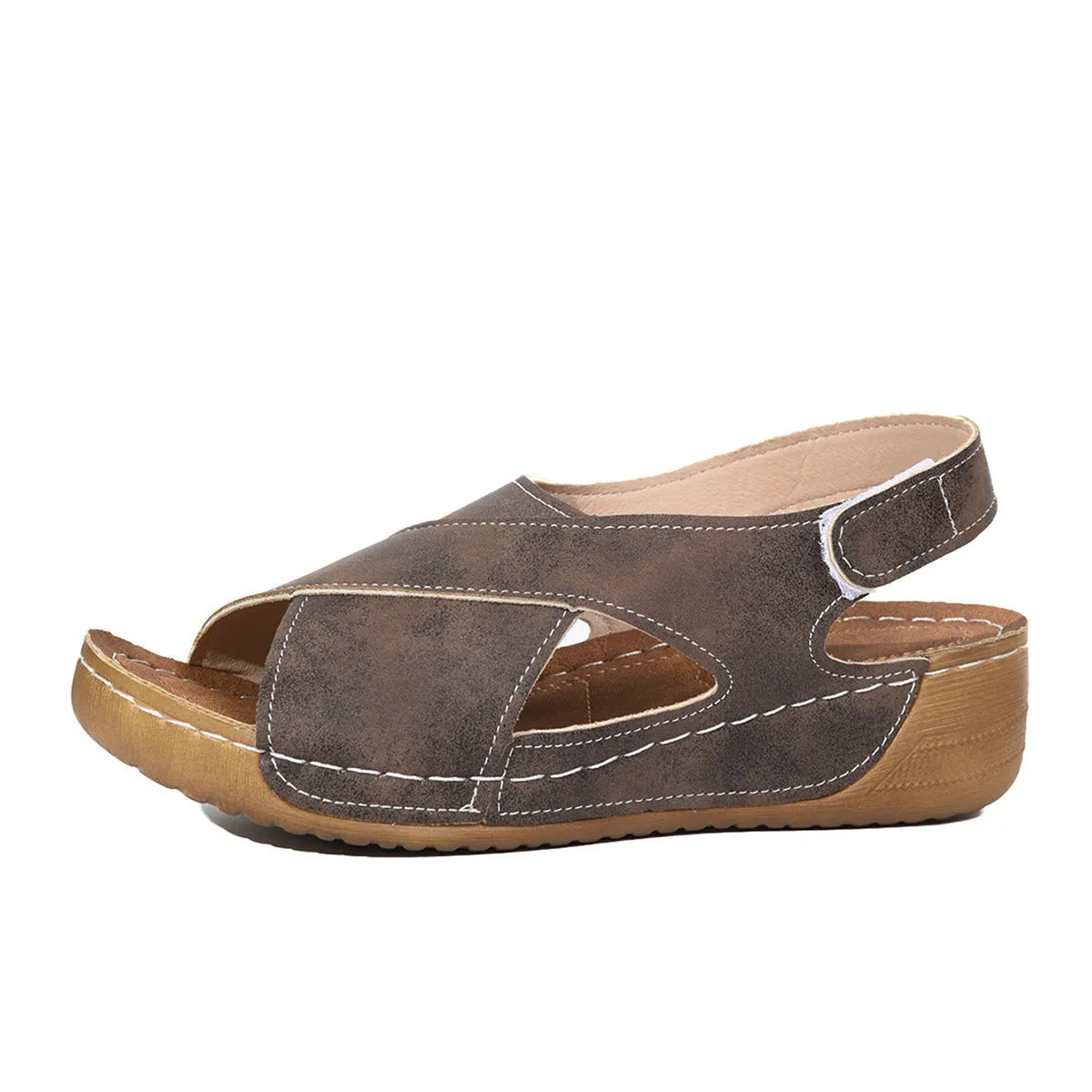 Women's brown platform Roman sandals with skirted ankle strap and Velcro fastening on a white background.