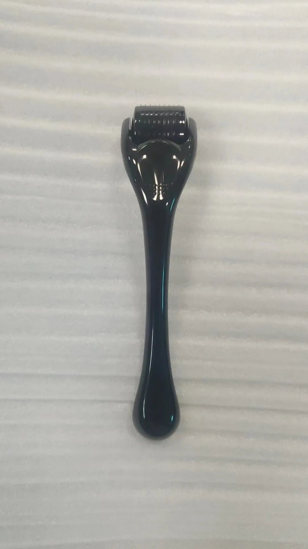 Black handle micro needle roller with purple wheel showing 540 stainless steel needles for dermaplaning