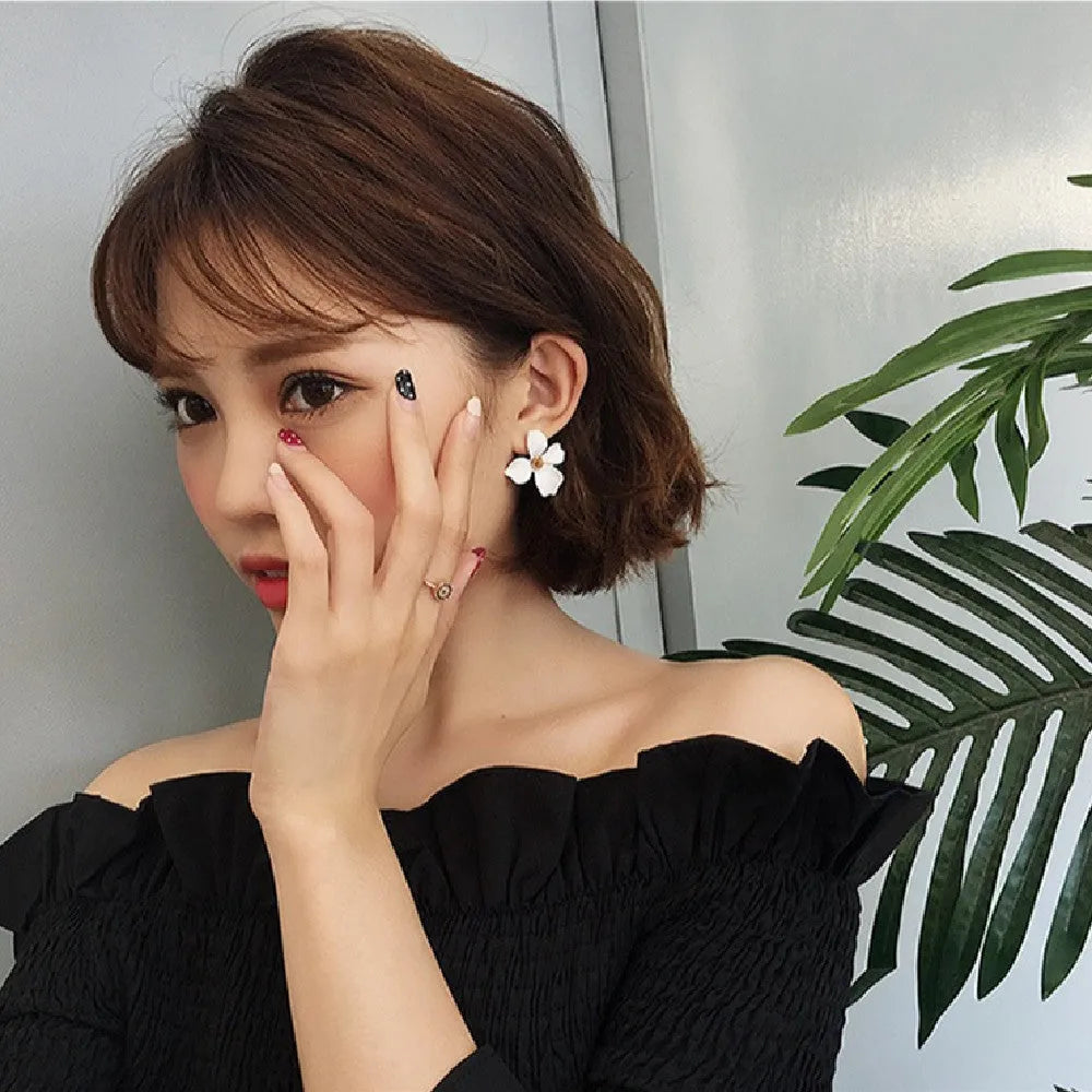Women's flower stud earrings with electroplated pink or white finish on alloy construction