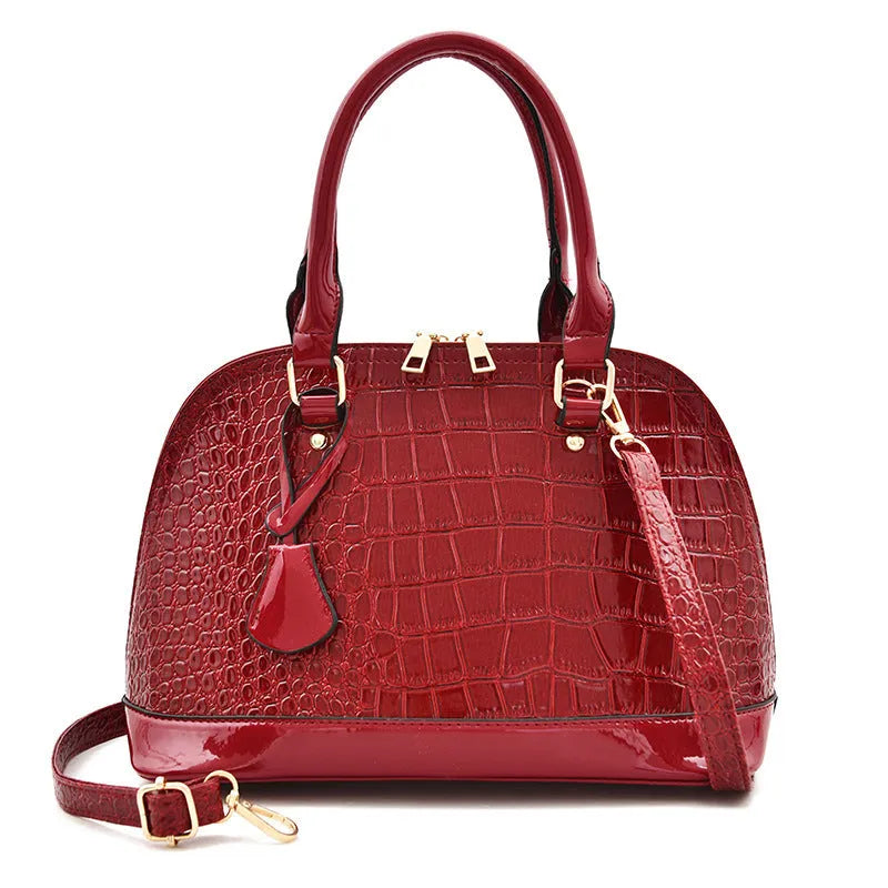 Shiny PU crossbody shoulder bag in shell shape showing black, red, and brown colour options