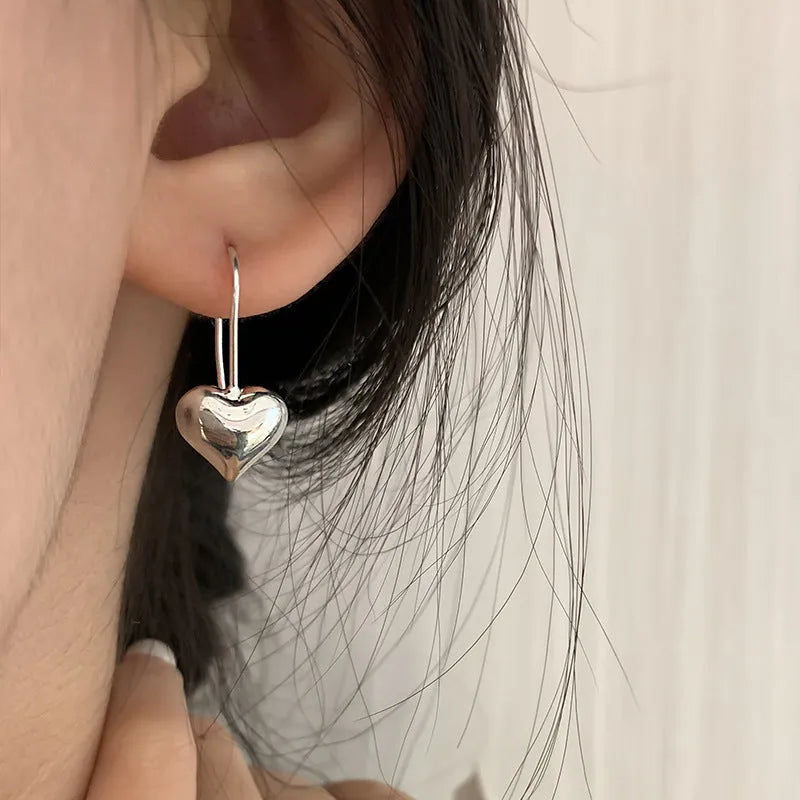 Silver tone heart-shaped earrings with glossy finish and Korean style design