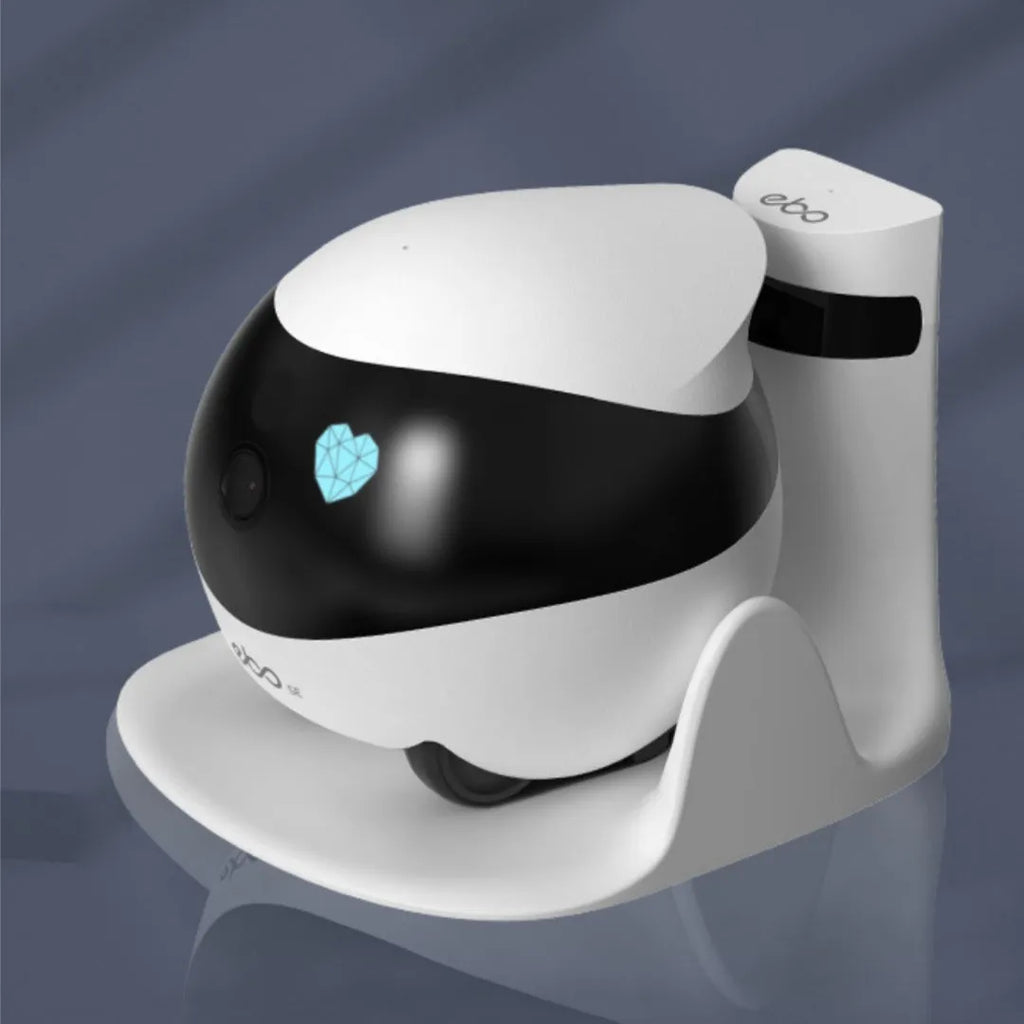 White smart home mobile surveillance robot camera on a charging dock.