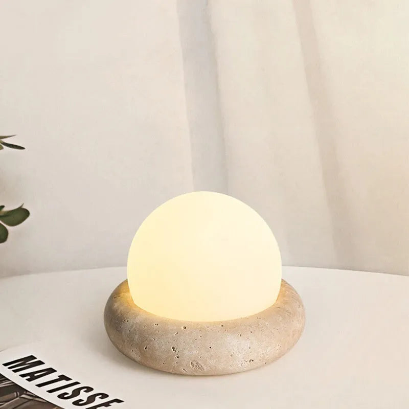Cream modern bedside table lamp with remote control on wooden surface