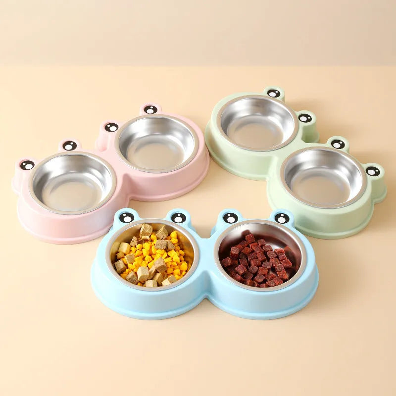 Stainless steel frog-shaped double bowl for pet food and water in blue, green, or pink.