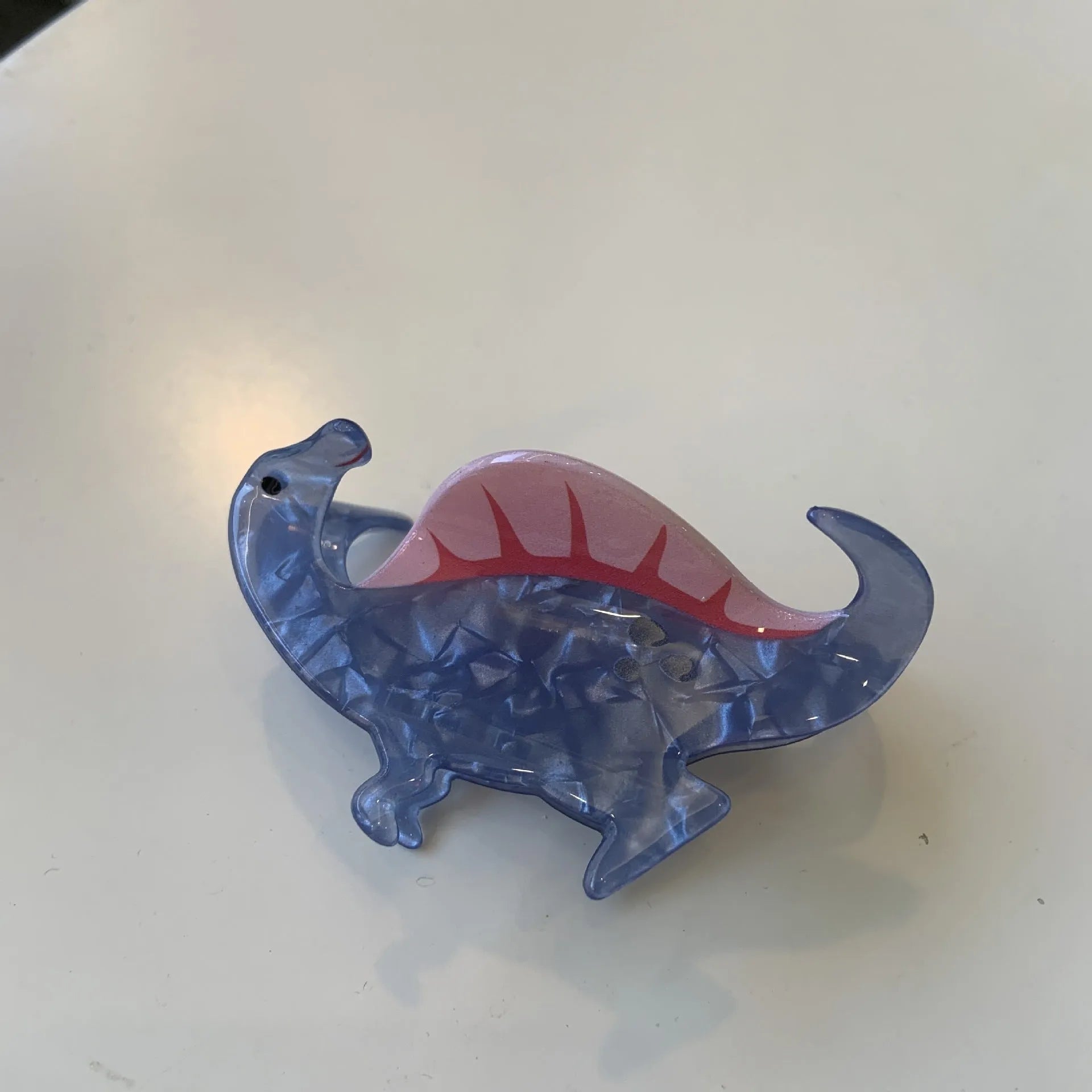 Acrylic dinosaur jaw grip hair clip showing six colour variations with prehistoric creature designs