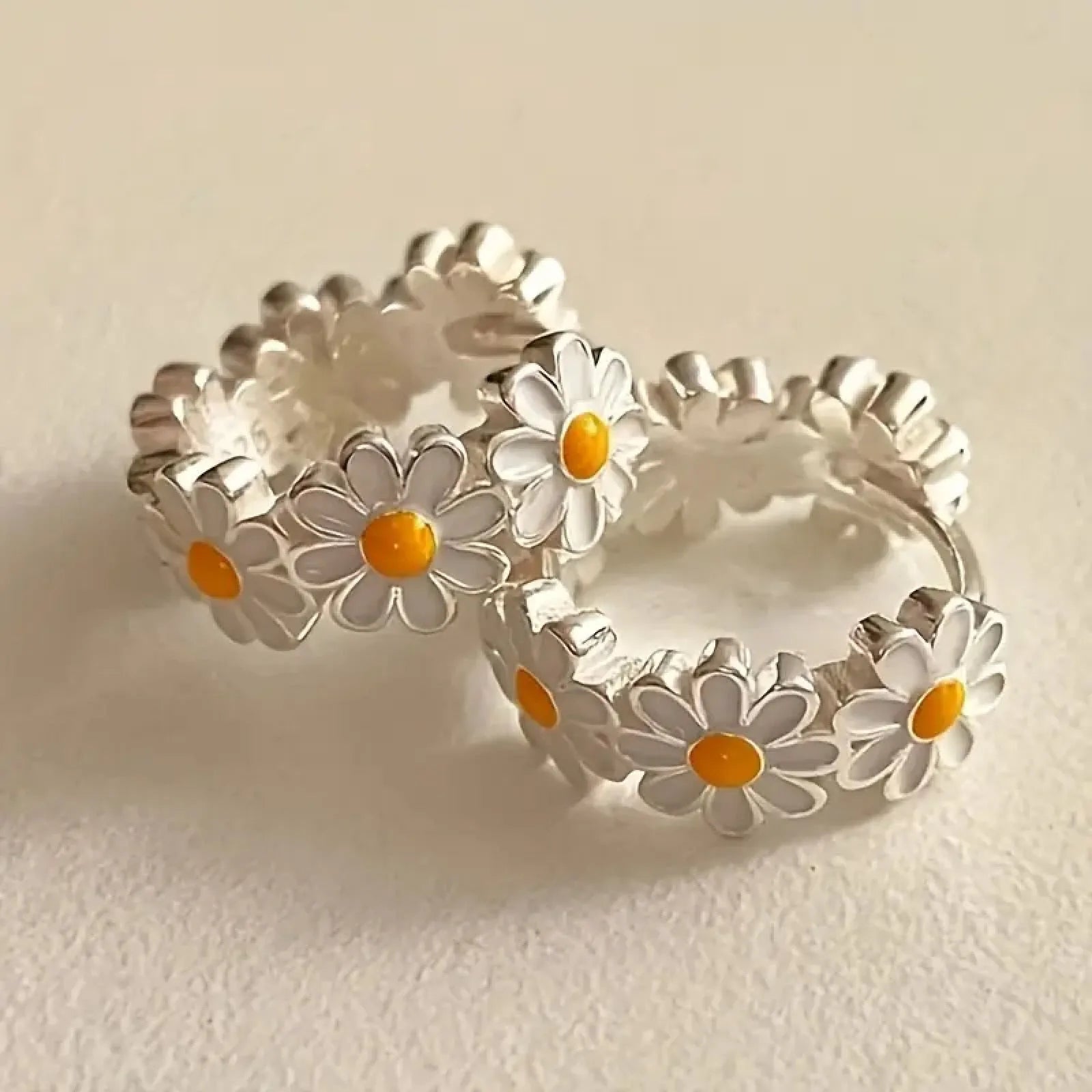 White daisy flower ring style fashion earrings with inlaid gems on a model or plain background.