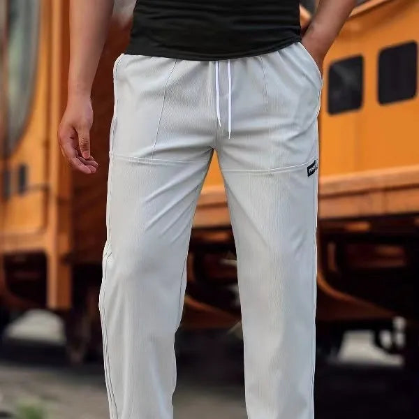 Men's polyester trousers in light grey, shown laid flat, suitable for spring and autumn wear.