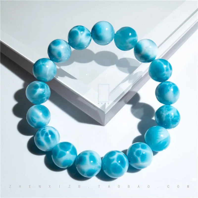 Blue natural Bodhi seed and crystal sea-pattern stone bracelet with a single pearl accent on a wrist.