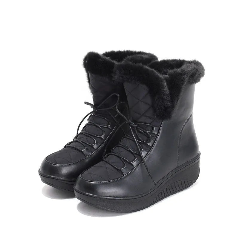 Women's black lace-up winter boots with a platform sole and plush lining on a wooden floor.