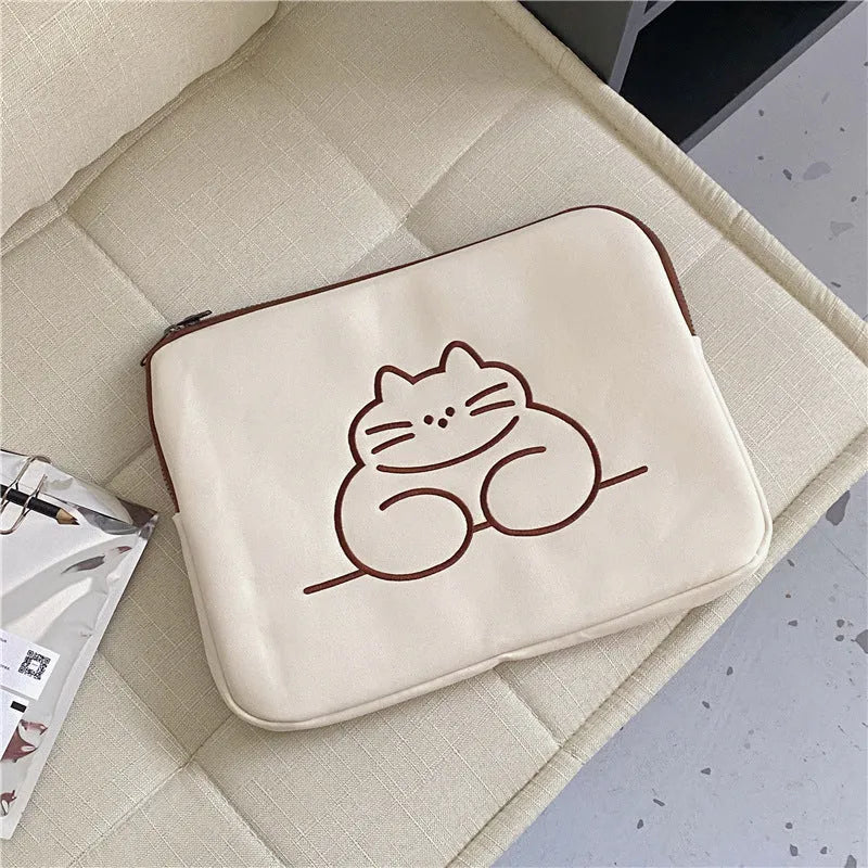 Embroidered fat cat design on a navy blue nylon tablet protective sleeve with a black zip.