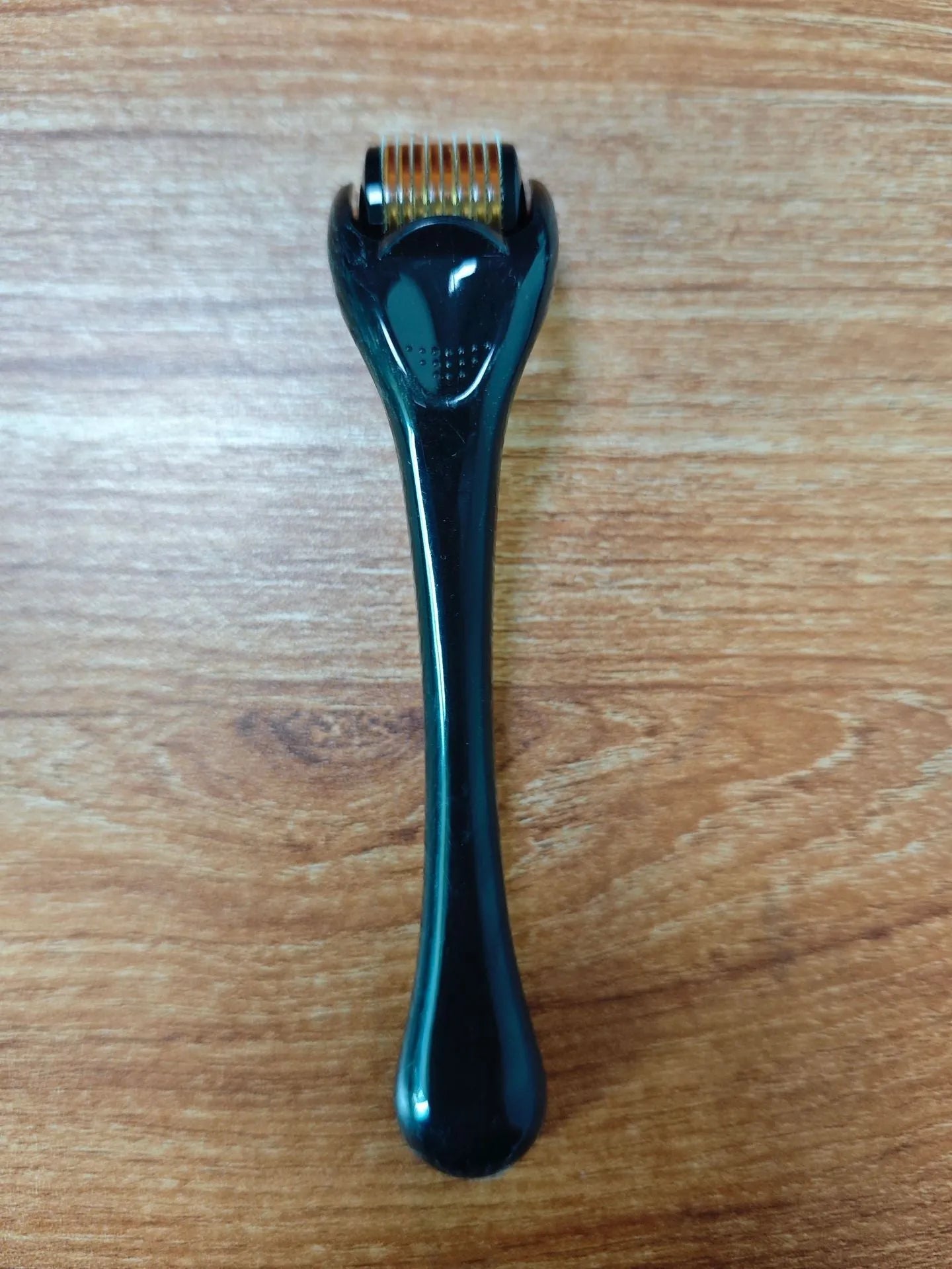 Black handle micro needle roller with purple wheel showing 540 stainless steel needles for dermaplaning
