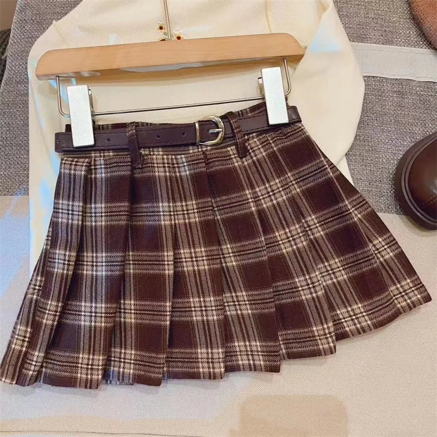 Girls plaid pattern pleated A-line skirt in cotton blend fabric on a hanger.