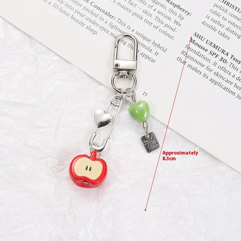 Plastic resin fruit pattern phone charm keychain pendant with apple and strawberry designs on a white rope.