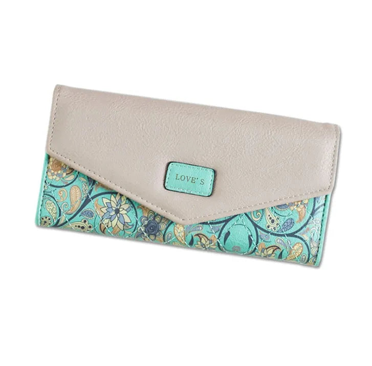 Women's black trifold leather wallet with buckle clip closure showing card slots and coin compartment