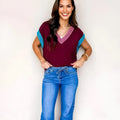 Burgundy women's loose V-neck sweater with contrast trim and cuffed short sleeves.