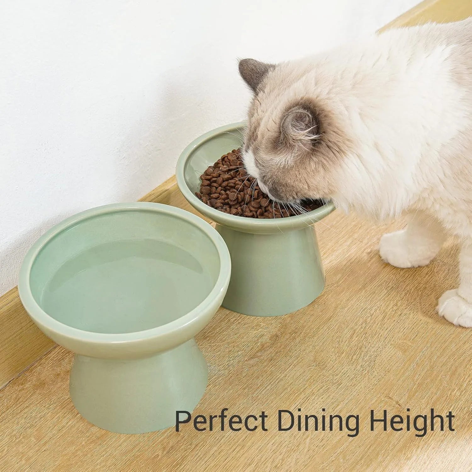 Blue ceramic elevated cat food bowl with wide shallow design next to a matching water bowl.