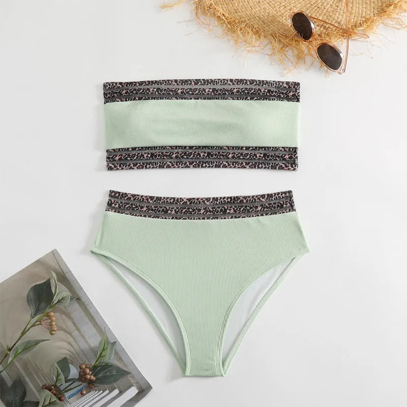 Black strapless bikini top and shorts with leopard print detail, laid flat.
