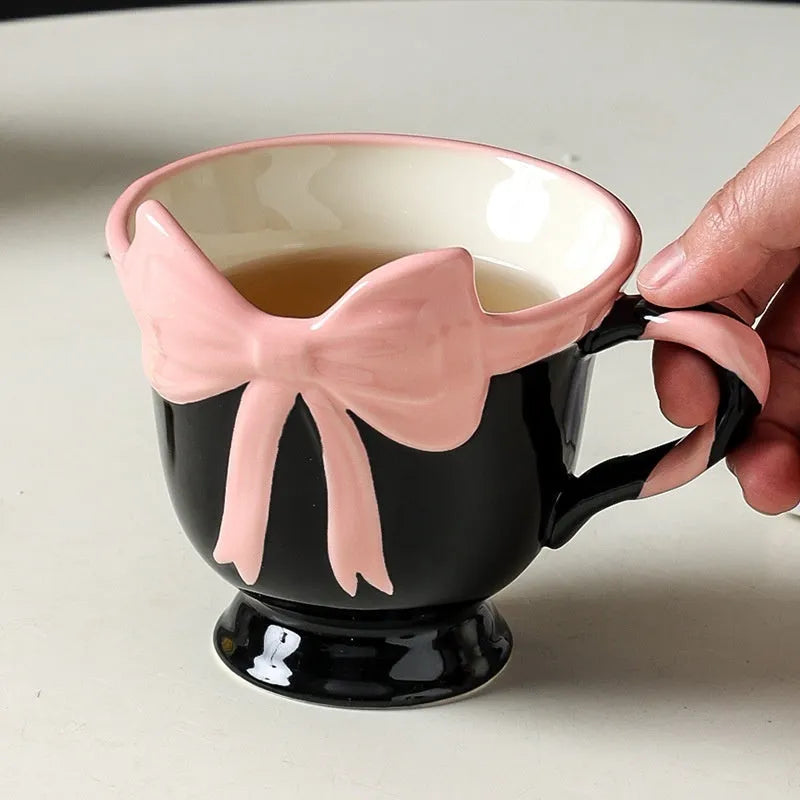 Ceramic mug with heart bow design in cute style showing Black Pink and White Powder colour options