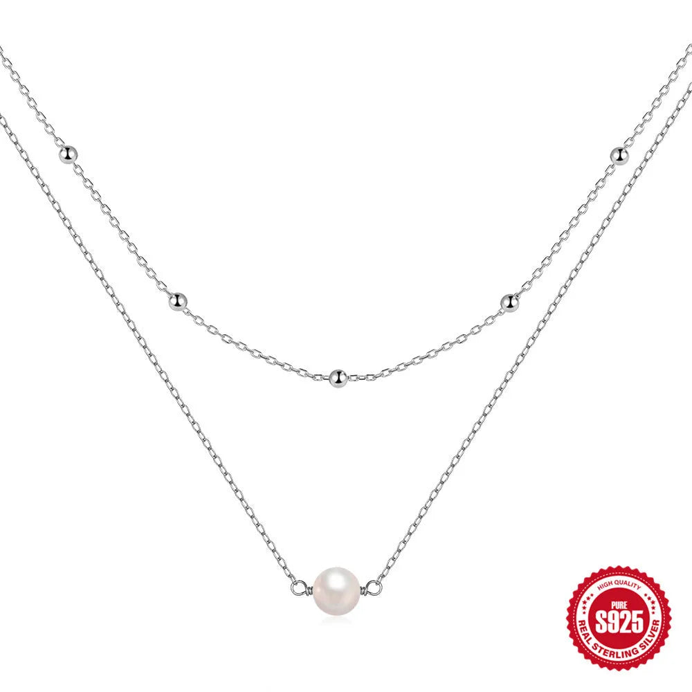 S925 sterling silver double layer necklace with twin pearls in gold or white gold finish featuring geometric pendant and ball bead chain.